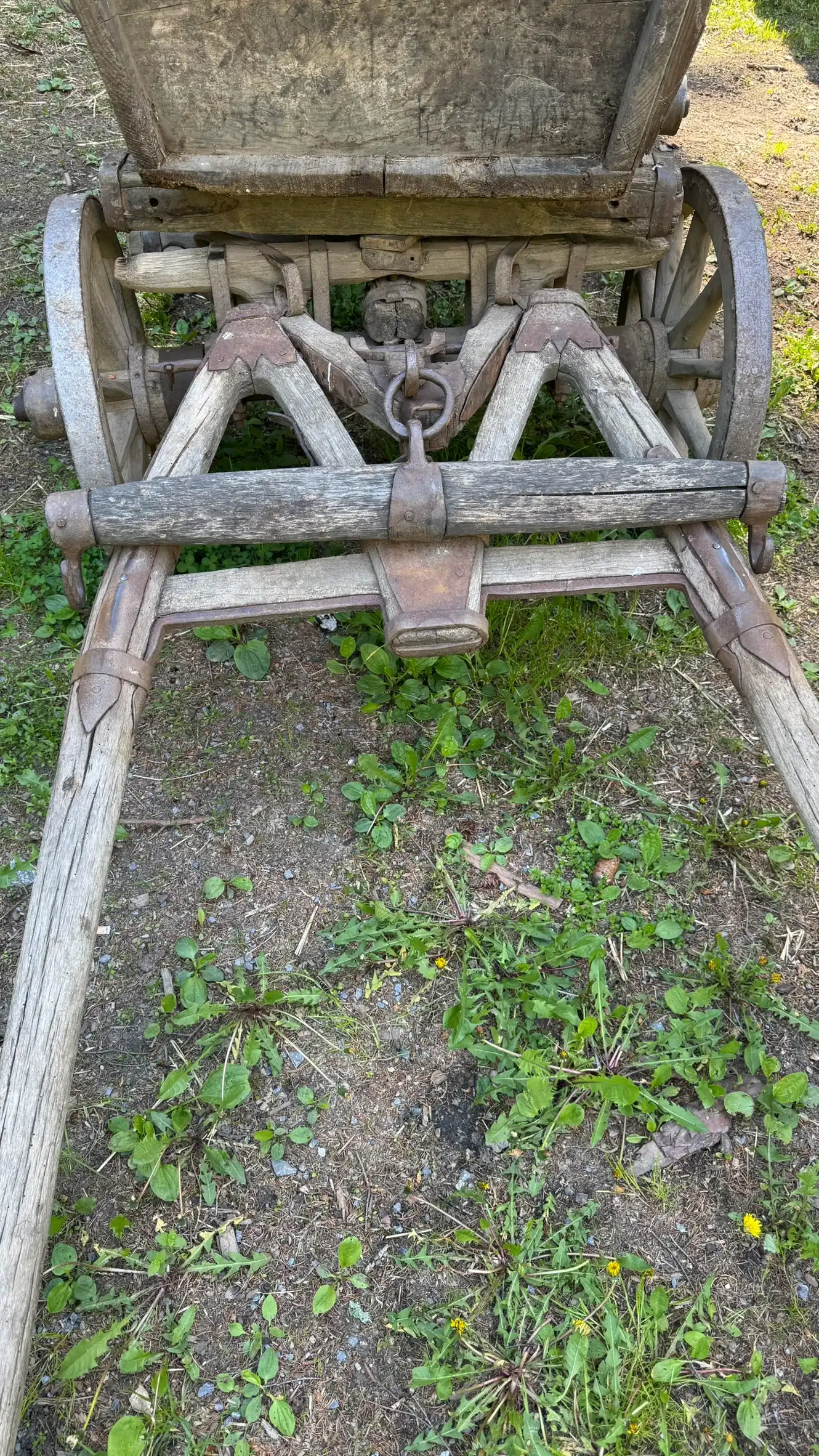 Deichselkonstruktion mit geschmiedeten Eisenbeschlägen und zentraler Kettenverbindung. Die schwenkbare Vorderachse ermöglicht die Lenkung des Wagens.