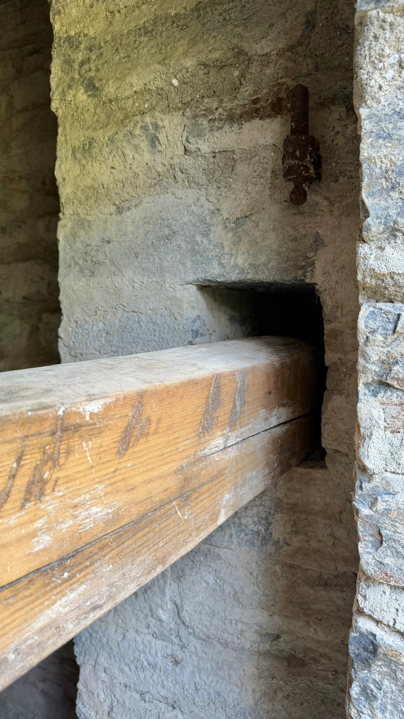 Die Holzsperre ist in einer rechteckigen Mauernische befestigt. Ansicht von außen.