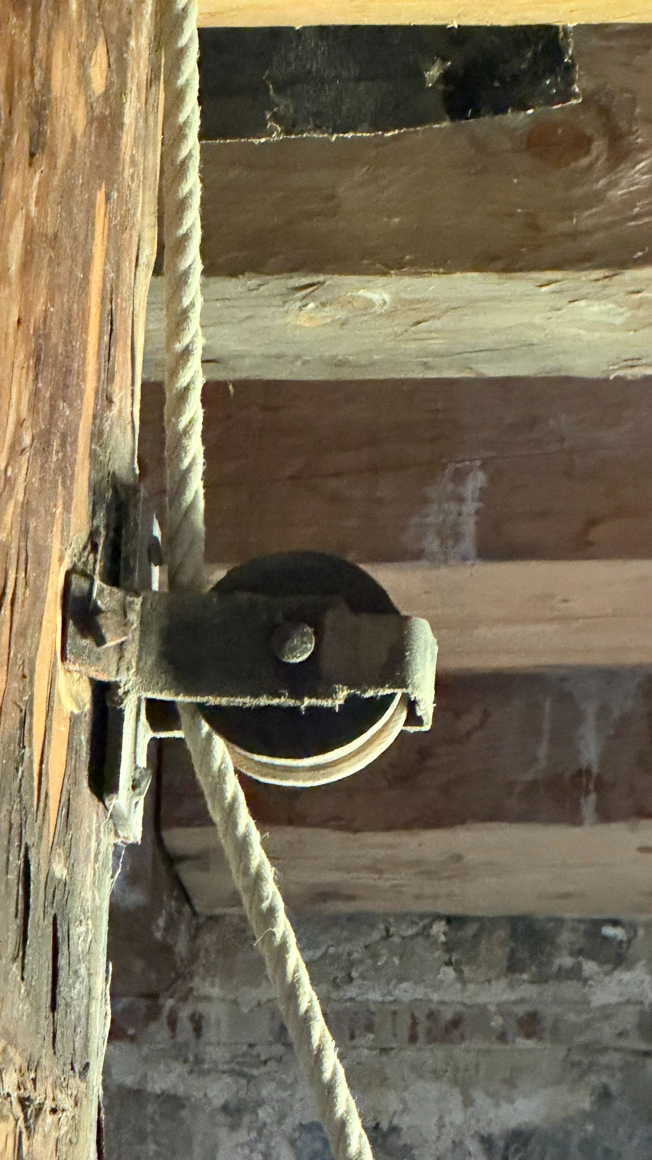 Umlenkrolle für das Seil der Winde, auf einem Holzbalken montiert und während des Turmbaus verwendet.