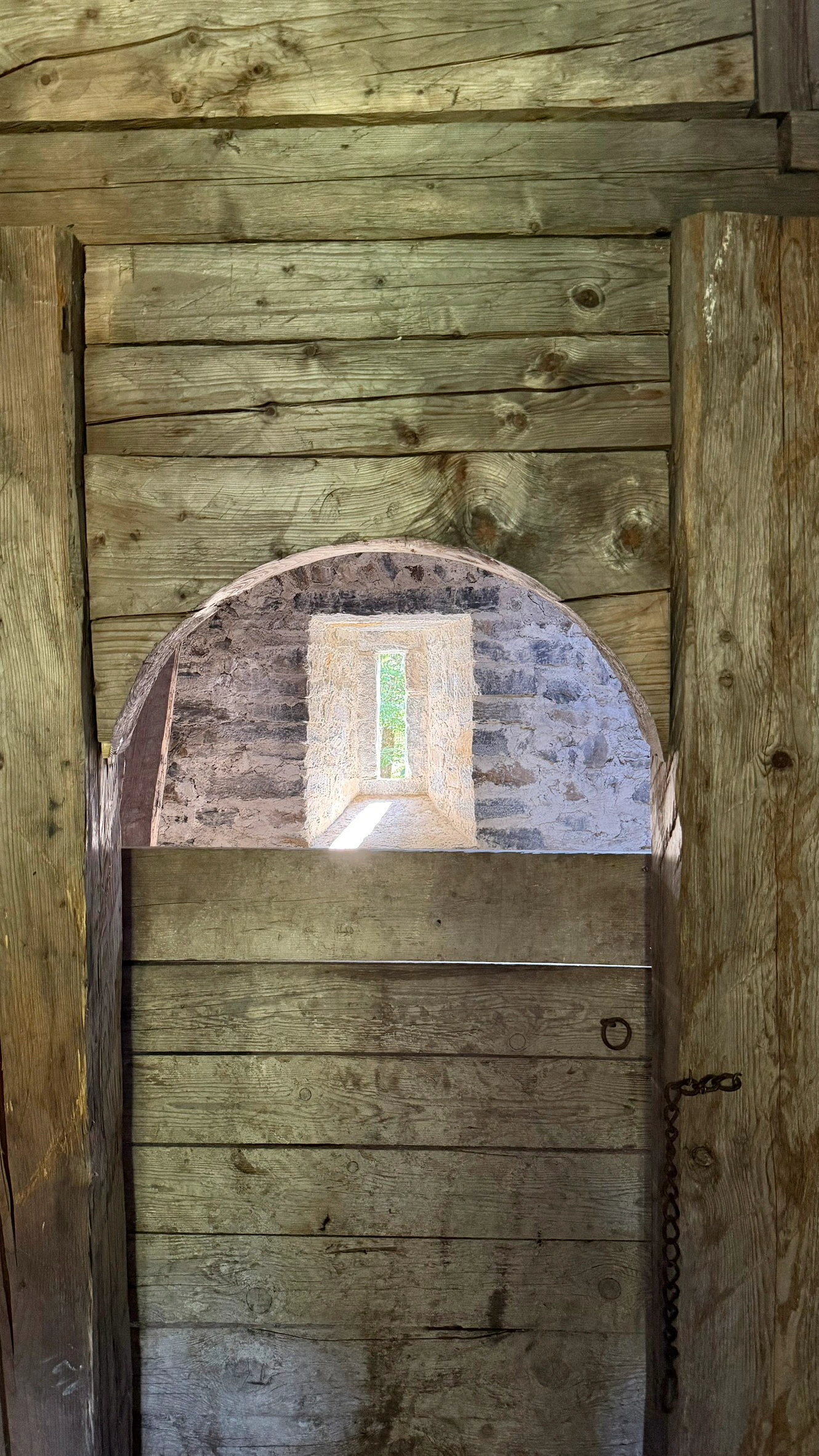 Wooden door leading from the summer room to the sleeping chamber.