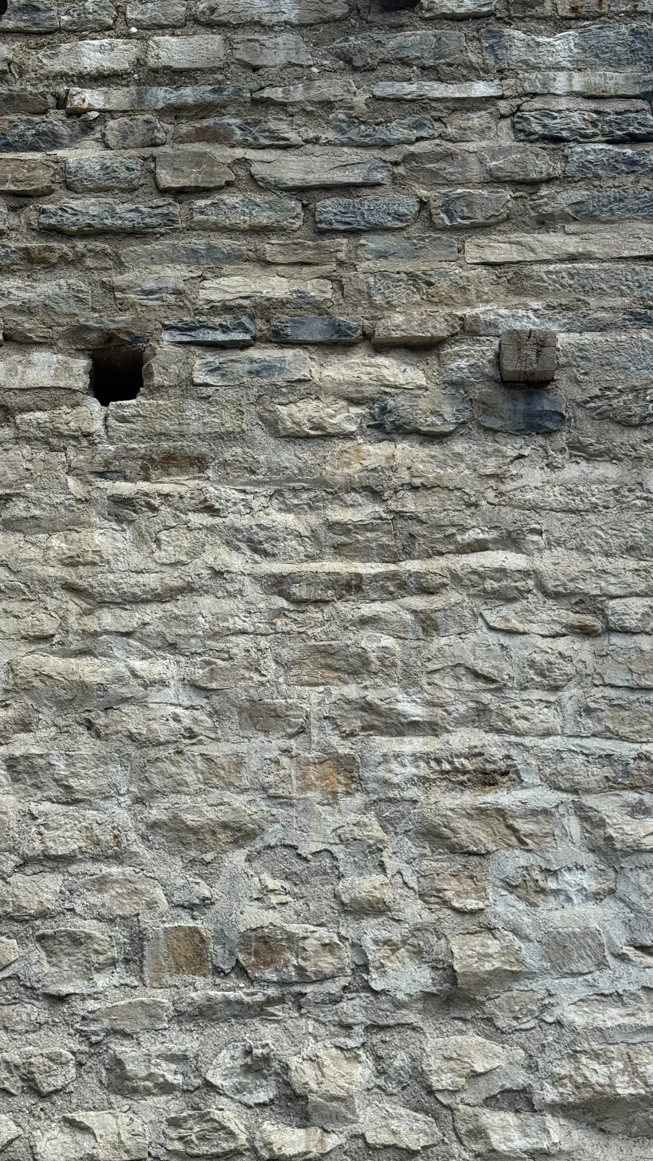 Quadratische Öffnungen im Mauerwerk und auskragende Balken markieren das ehemalige Holzgerüst.