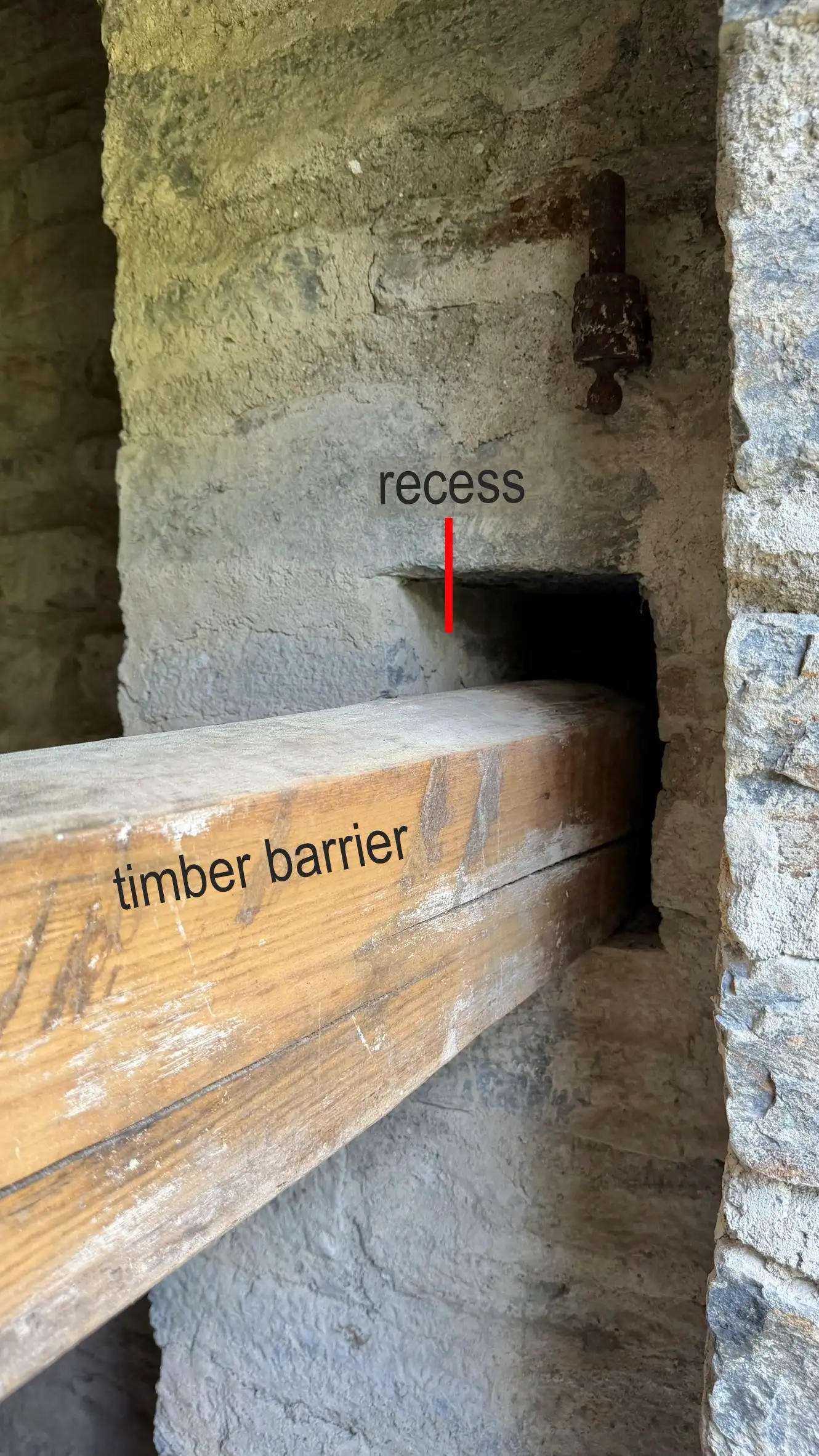 The timber barrier is secured in a rectangular wall recess. Viewed from outside.