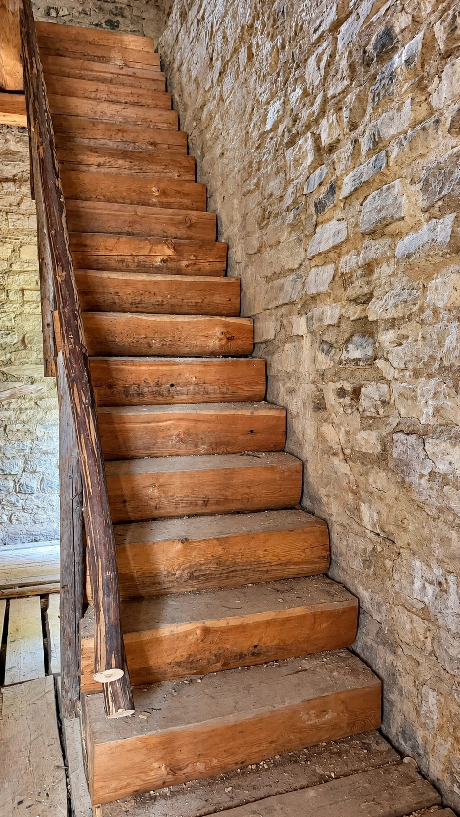 The wooden staircase on the entrance level leads to the residential level above.