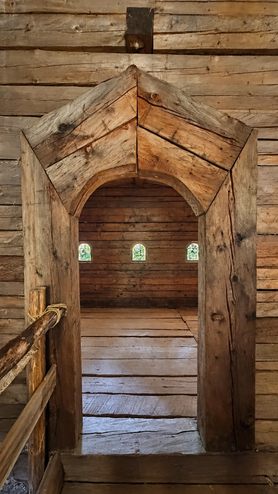 Holztürrahmen mit Blick in die Winterstube. Drei rundbogige Öffnungen in der Ostwand sind sichtbar.