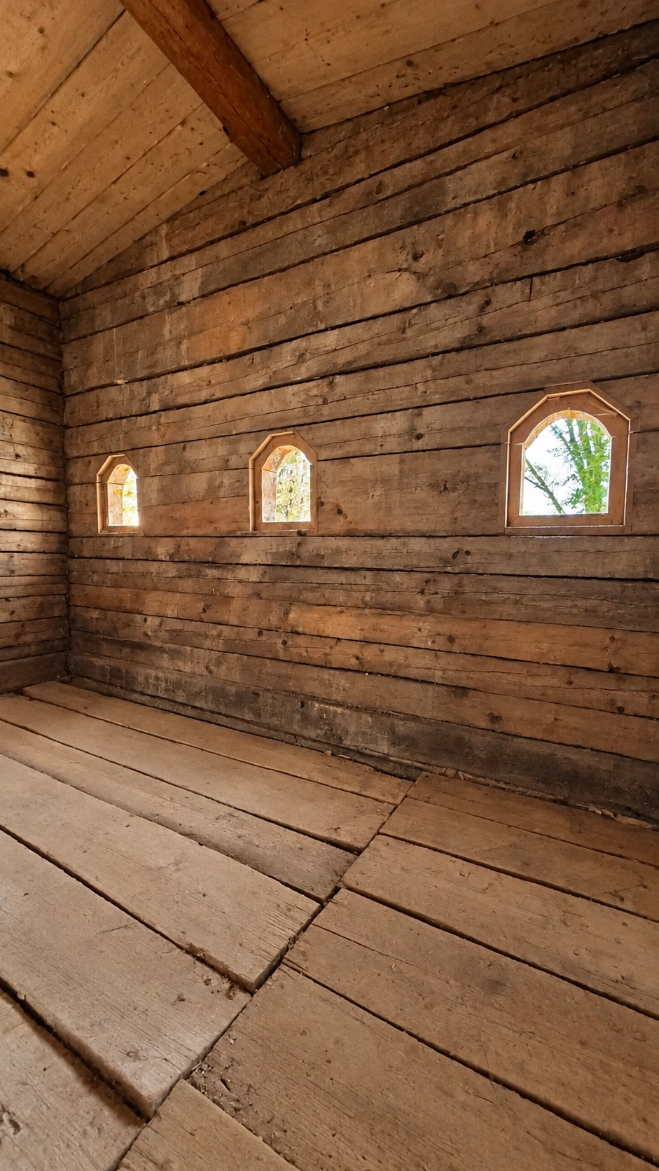 Three round-arched openings in the east wall. Timber floorboards in the foreground.