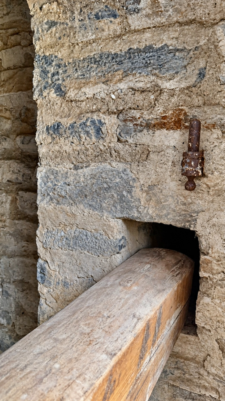 Die Holzsperre ist in einer rechteckigen Mauernische befestigt. Ansicht von außen.