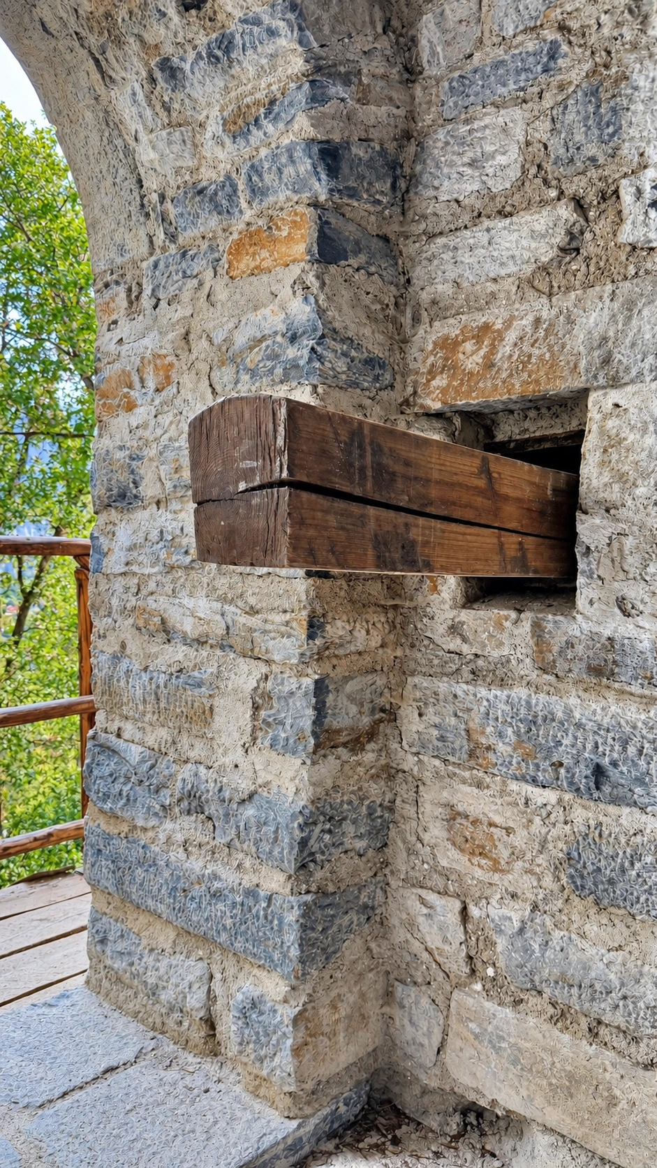 Ein zugeschnittener Holzbalken ist in eine rechteckige Mauernische eingesetzt. Ansicht von innen.
