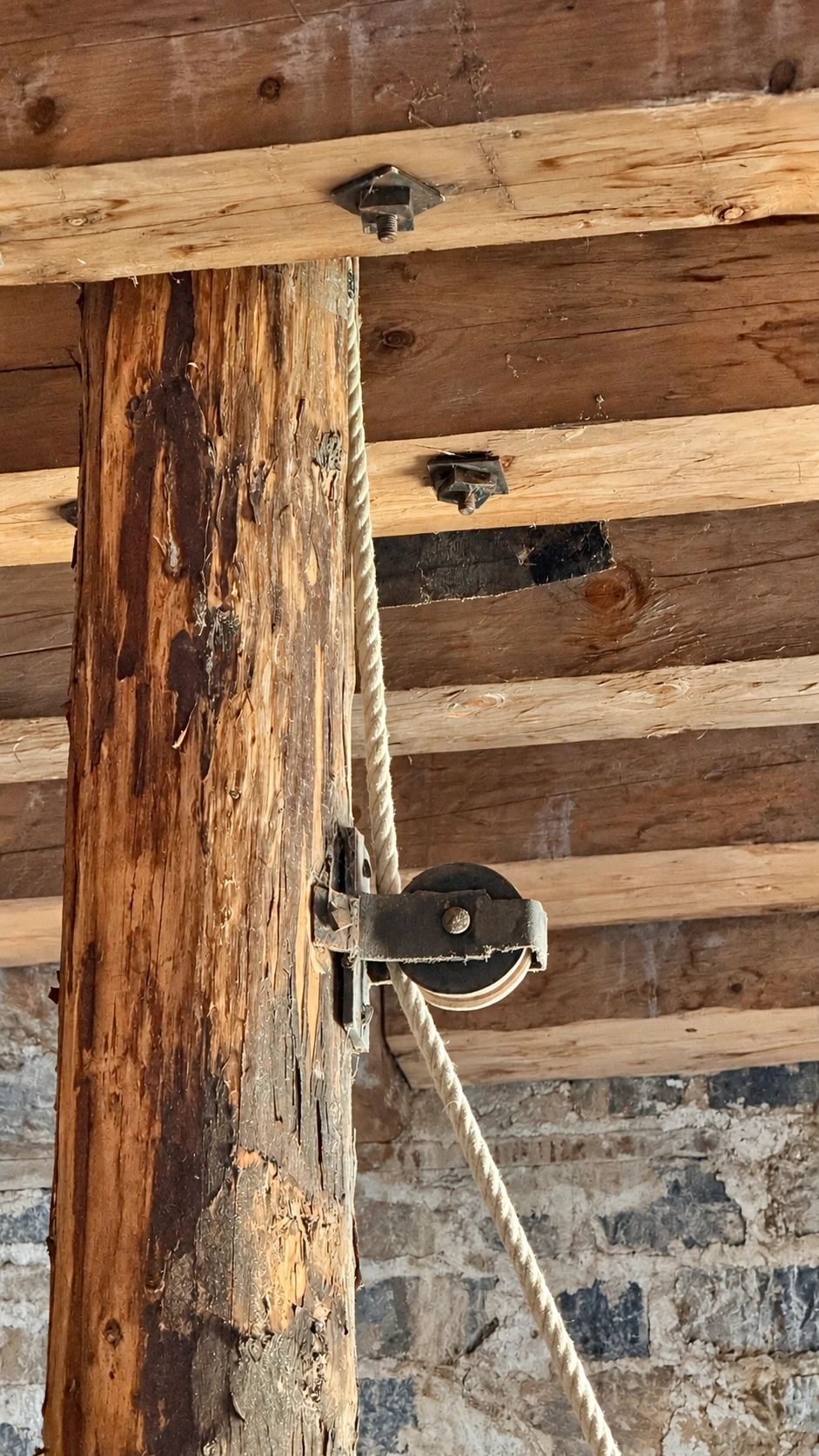 Guide pulley for the winch rope, mounted on a timber beam and used during the tower's construction.