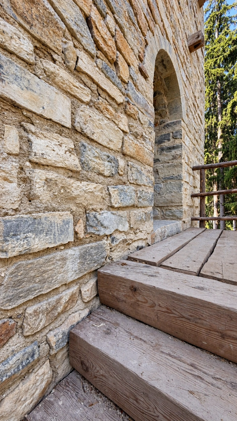 Holztreppe zum Podest vor dem Hocheingang.
